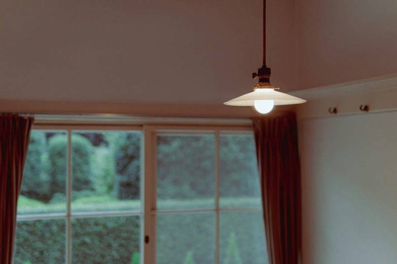 a light hanging from a ceiling in front of a window
